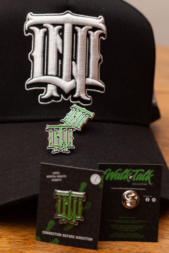 Walk Talk Collective cap and green enamel pins