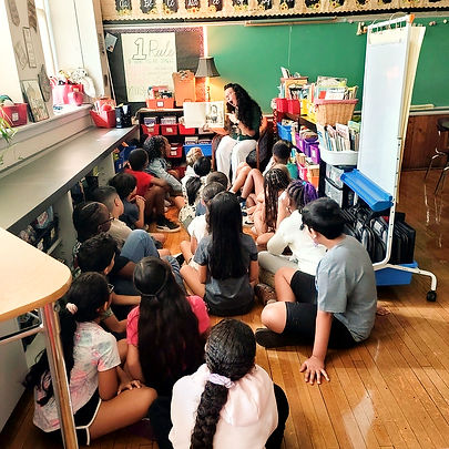 A teacher makes silly faces as she reads to a group of students.
