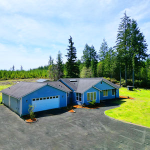 Blue home with green grass. fix and flip property by Irelandhomes