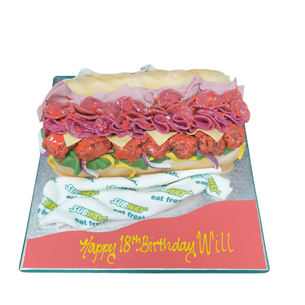 Cake decorated to look like a Subway sub sandwich, with layers of sponge and frosting in sandwich form, perfect for sandwich lovers.