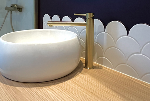 Aménagement d'un grand meuble vasque à tiroirs pour maximiser le stockage dans une petite salle d'eau.