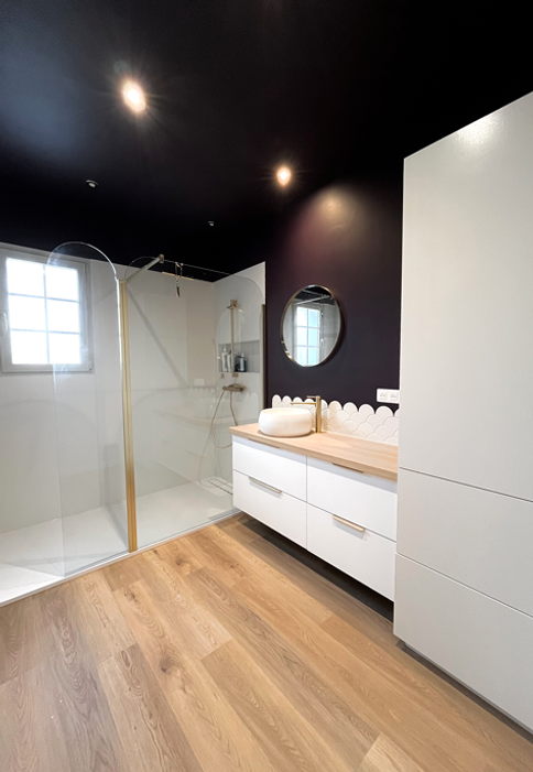 Transformation d'une salle de bain : remplacement d'une baignoire d'angle par une grande douche moderne.