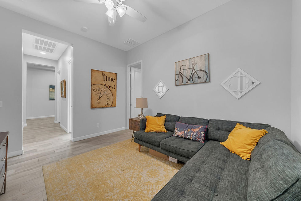 Modern living room with grey sofa, yellow pillows, and rug