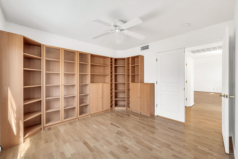Empty room with built-in wood bookshelves and wood floor