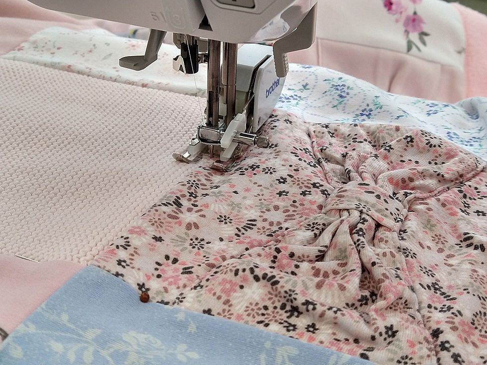 Thumbnail: Close up sewing machine quilting between a pink square and a pink floral square with a bow.