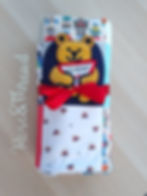Thumbnail: Completed blanket with a teddy on the front. Rolled up and tied with a red bow.