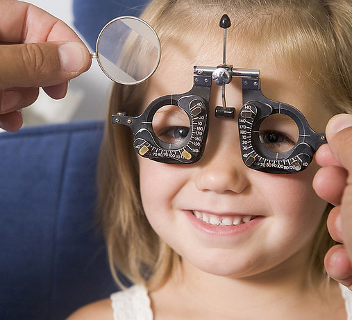kid having her eyes tested by an optician