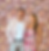 Smiling couple with flower wall photo booth backdrop
