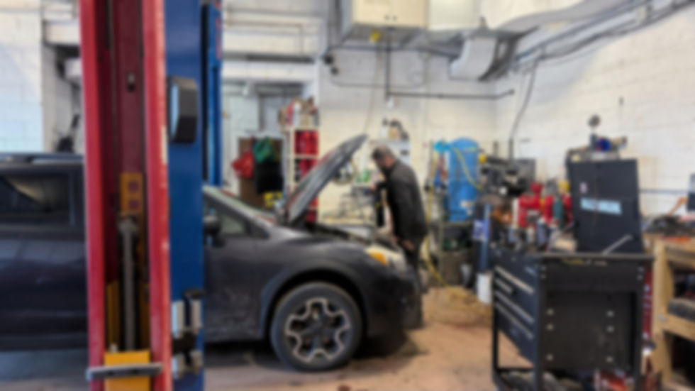 Auto mechanic working on car in garage