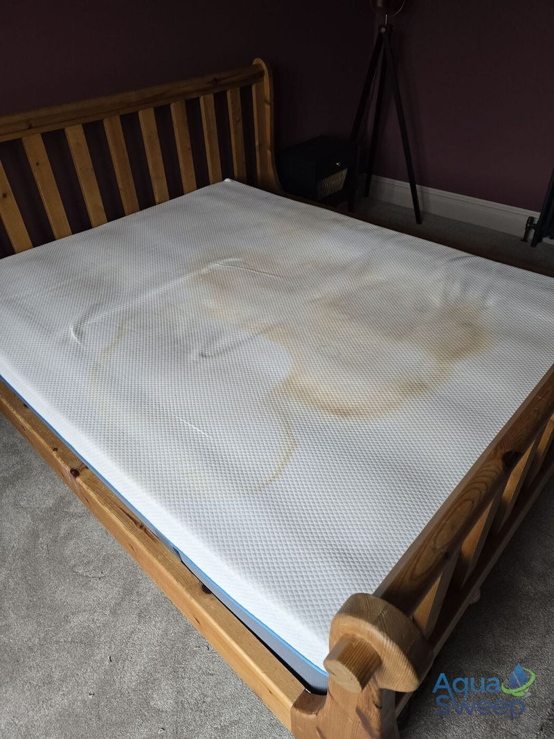 Mattress with large yellow stains before cleaning
