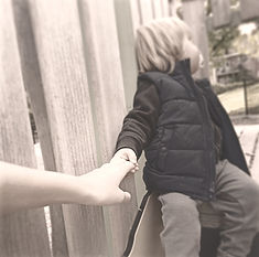 une femme tenant la main d'un petit garçon (marraine et son filleul)
