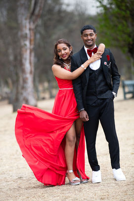 happy couple in red dress and black suit at graduation