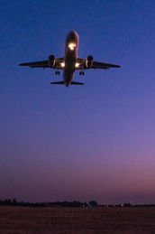 Commercial airplane taking off with landing lights at dusk