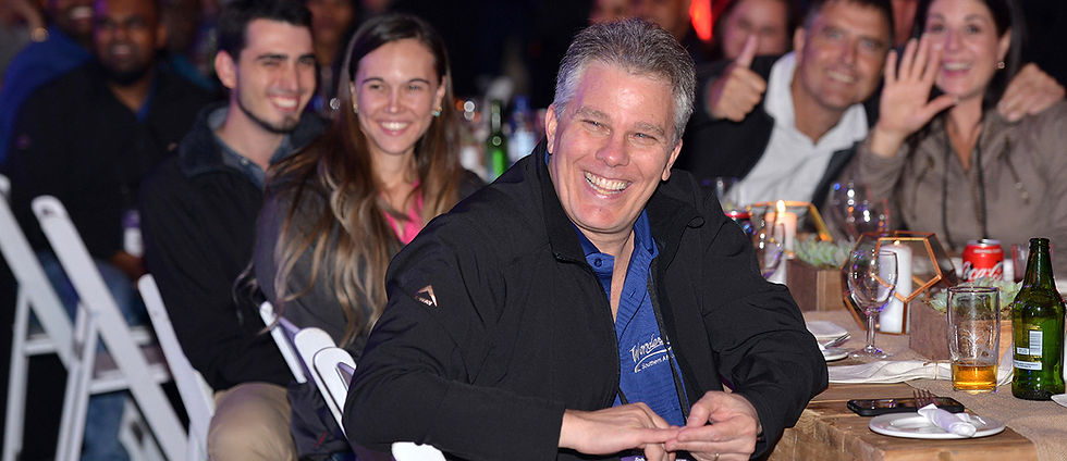 Man laughing with group of people at a social event at an event