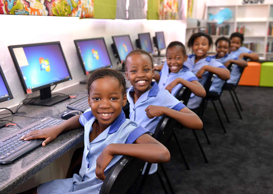 Smiling students using computers in a lab