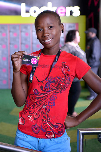 Smiling student holding an ID card in front of lockers