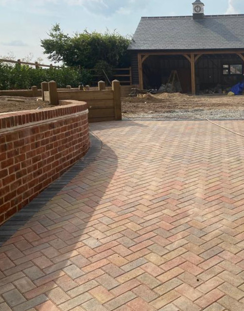 A in progress brick weave driveway and brick wall by compass construction