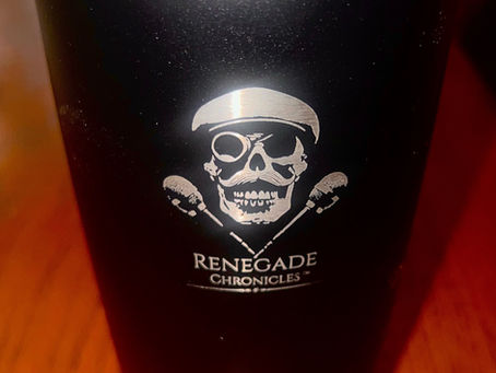 Image of a black tumbler featuring the Renegade Chronicles logo — a skull with a mustache, monocle styled like a camera lens, and a flat cap, flanked by two crossed microphones. The background is textured with bold red and orange radial stripes, evoking a retro, broadcast-era vibe.