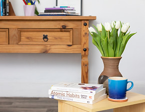 A table with coaching books, a blue cup and flowers on