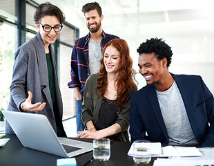 Four colleagues at a table looking at a computer