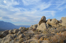 boulders cloudy sky valley desert rocky mountains