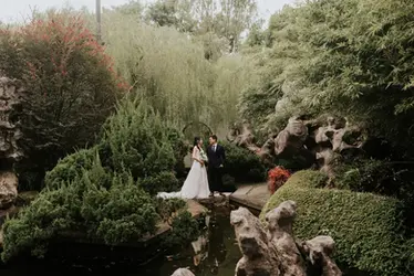 Bride and groom crossing a stone bridge at Chinese Garden during Singapore pre-wedding photoshoot.