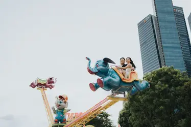Casual couple enjoying a rollercoaster ride during pre-wedding photoshoot at Uncle Ringo carnival.
