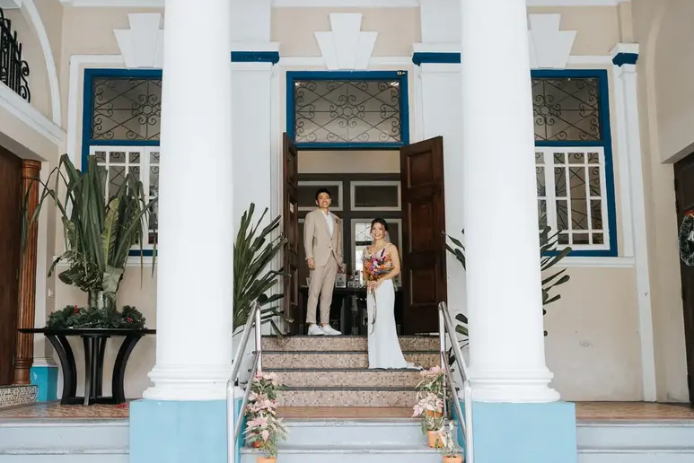 Bride and groom photographed together during their wedding festivities at the entrance of The Masons Table Singapore