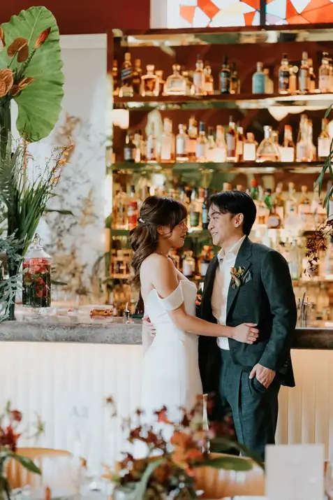 Claudine wedding couple posing in front of a bar
