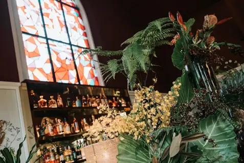 Wedding floral arrangement in front of a church bar.