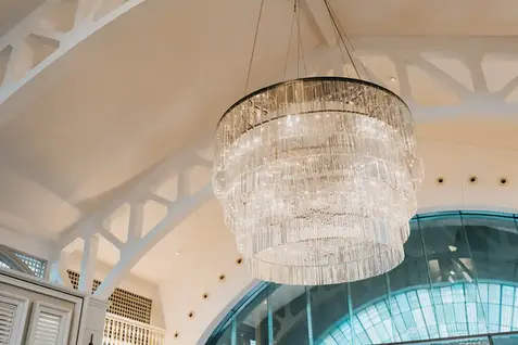 Large crystal chandelier hanging in a wedding venue