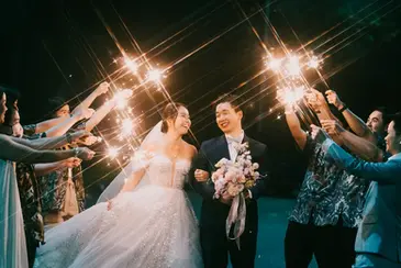 Bride and groom celebrating with bridal party holding sparklers after traditional Chinese wedding celebration at 1-Arden restaurant Singapore.
