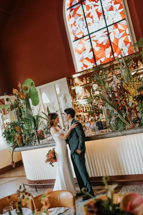 Bride and groom posing by the bar at Claudine wedding.