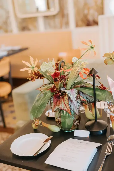 Wedding centerpiece with orange flowers and lush greenery