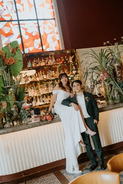 Bride and groom posing by a bar at Wedding Claudine