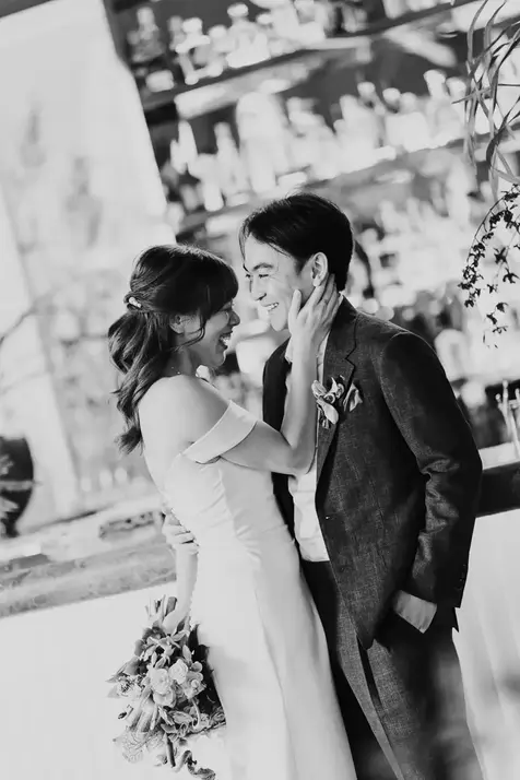 Bride Claudine and groom smiling at their wedding reception
