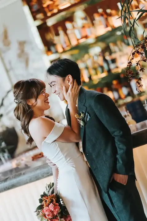 Bride Claudine and groom smiling together at the bar
