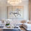 Thumbnail: Original horse painting above a cream sectional in a sophisticated, high-end living room with a crystal chandelier