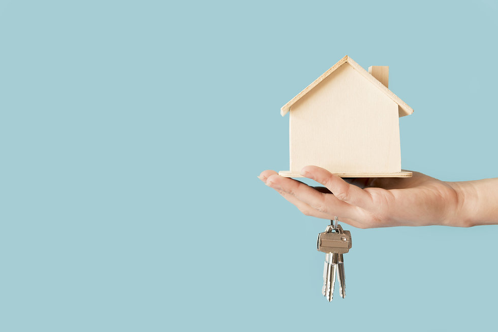 close-up-of-hand-holding-keys-and-wooden-house-model-against-blue-background (1).jpeg