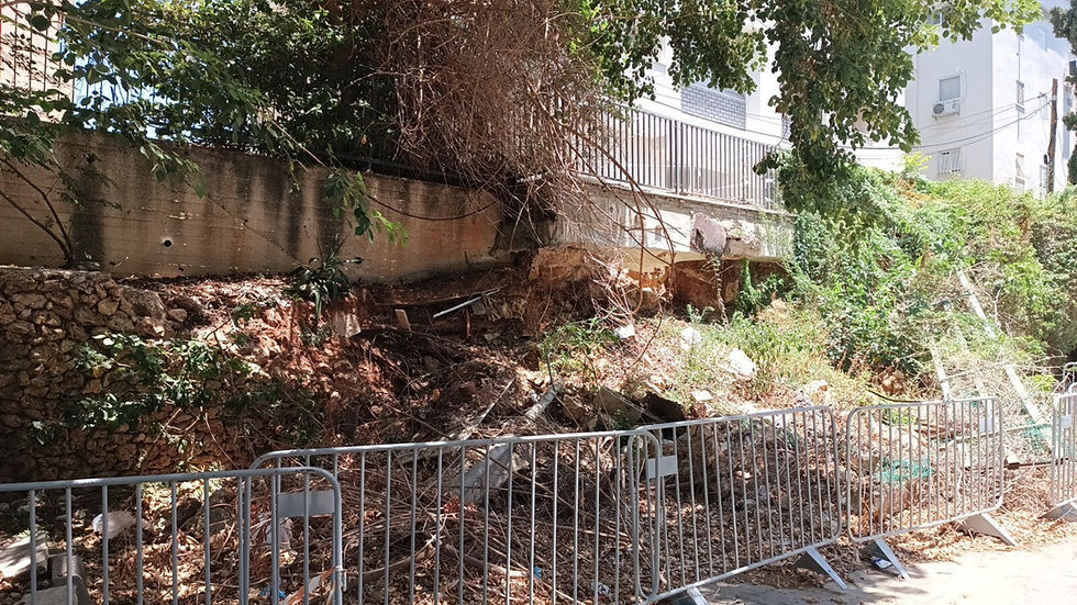 אזור קריסה של קיר תומך וסחף קרקע לצד המדרכה