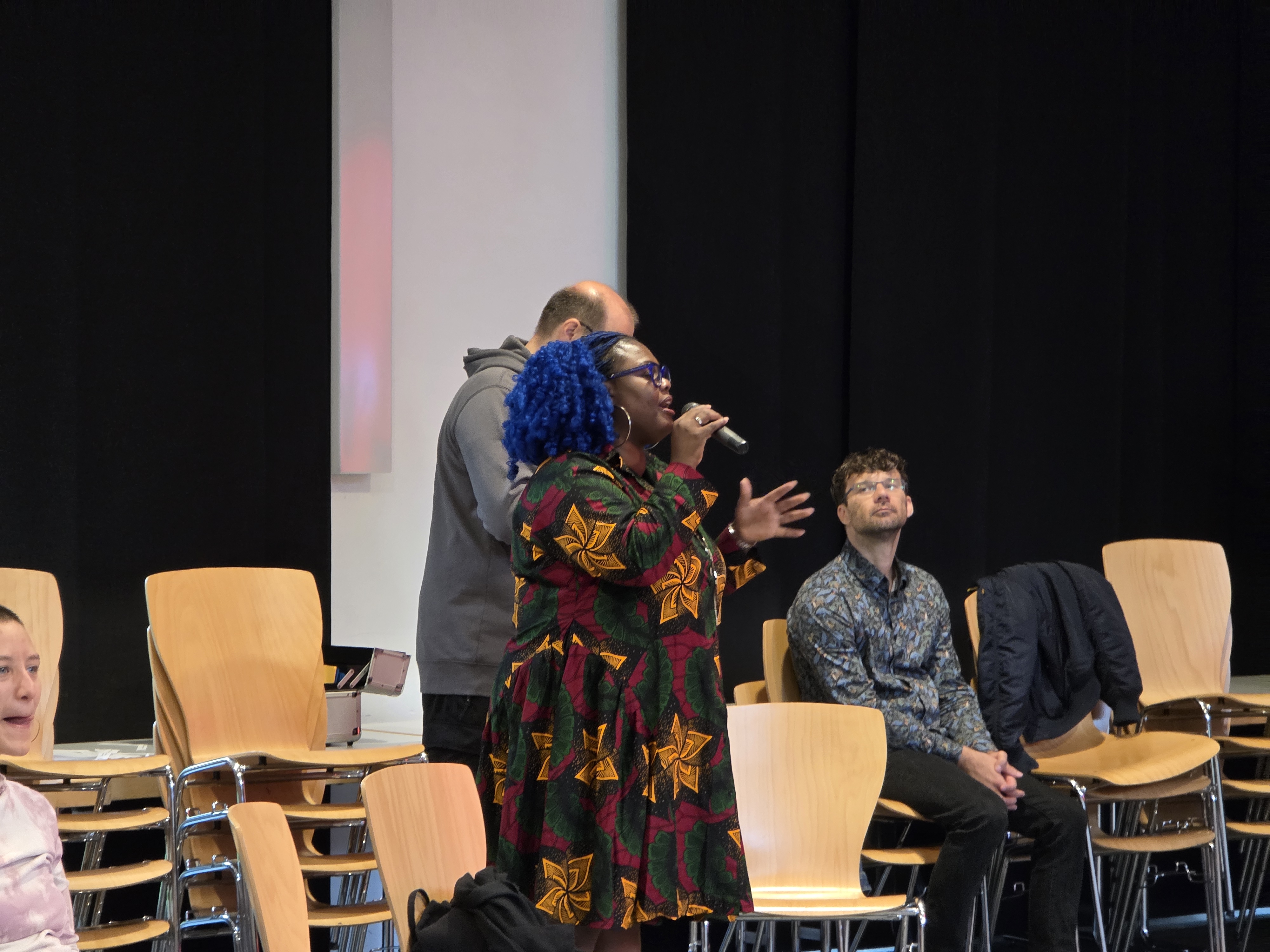 Rita speaking to an audience with a microphone