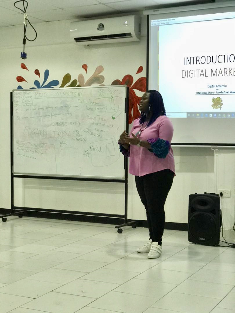 Rita facilitating a learning session beside a whiteboard