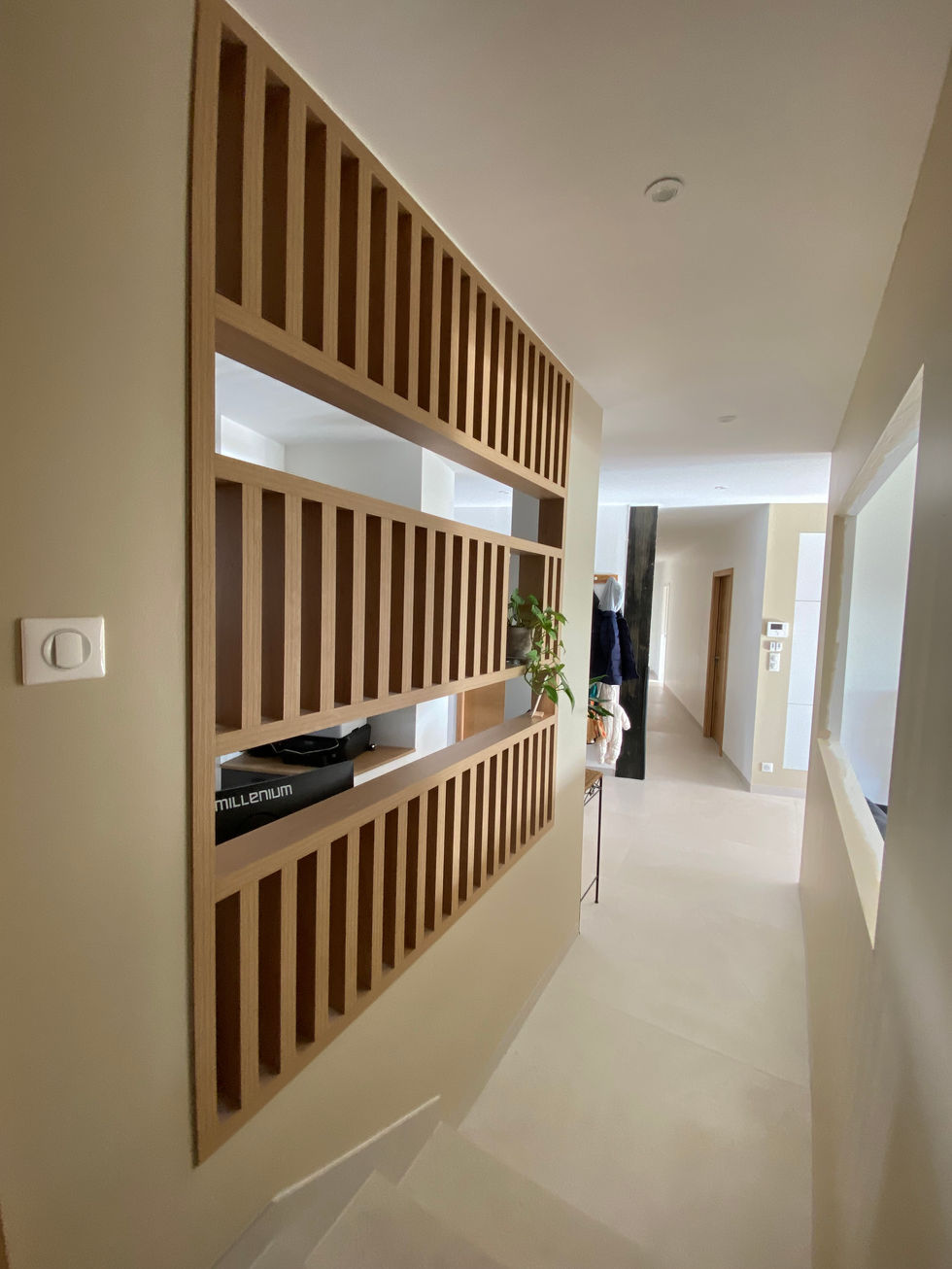 Un claustra en mélaminé imitation chêne délimite bureau et couloir