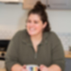 Amber standing in her kitchen with a rainbow mug