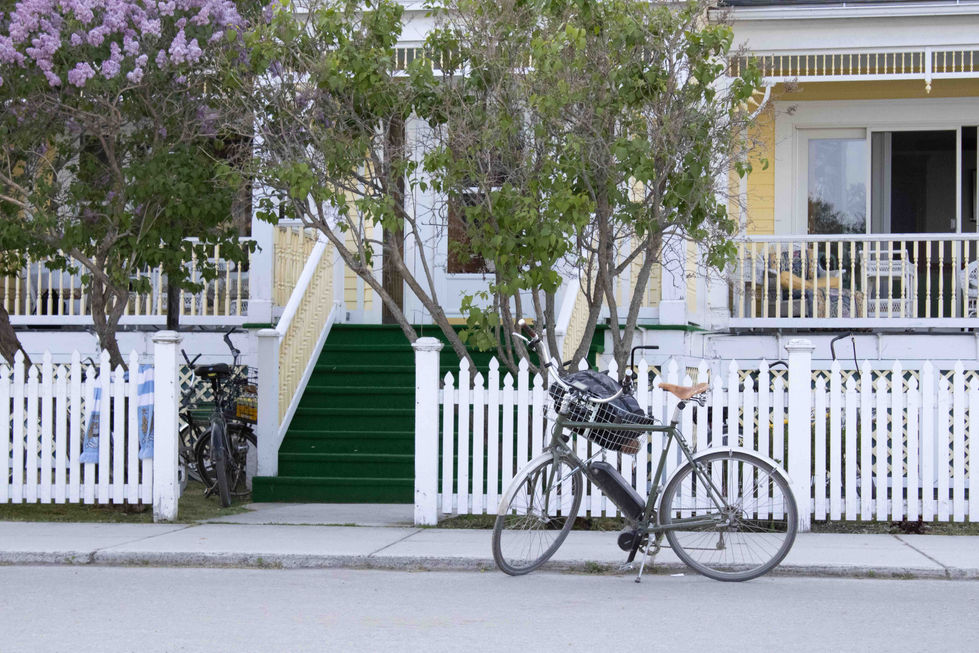 A bicycle in front of a yellow house
