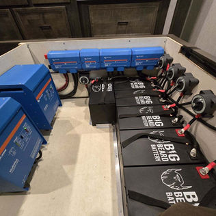 Victron inverters, lynx distributors, Big Beard Battery  lithium batteries and disconnects under bed inside RV