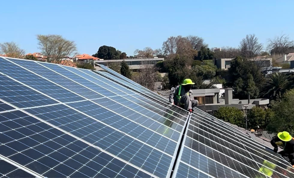 Eye-level view of solar panels installed on a residential rooftop under clear blue sky