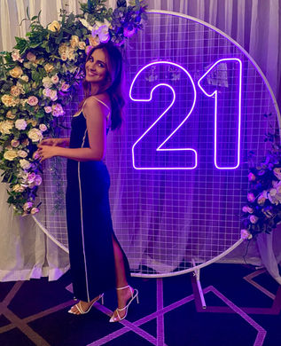 21 neon sign set to purple with white circular mesh stand and spring faux florals at Darling and Co Brisbane