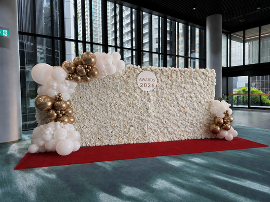 XL white flower wall with white and gold balloon garland, customised signage and red carpet 
