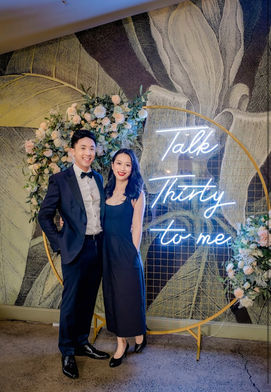 Talk Thirty to me neon sign with gold circular mesh stand and spring flower garland at Paw Paw Brisbane